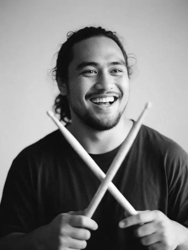 Kai lachend mit gekreuzten Drumsticks